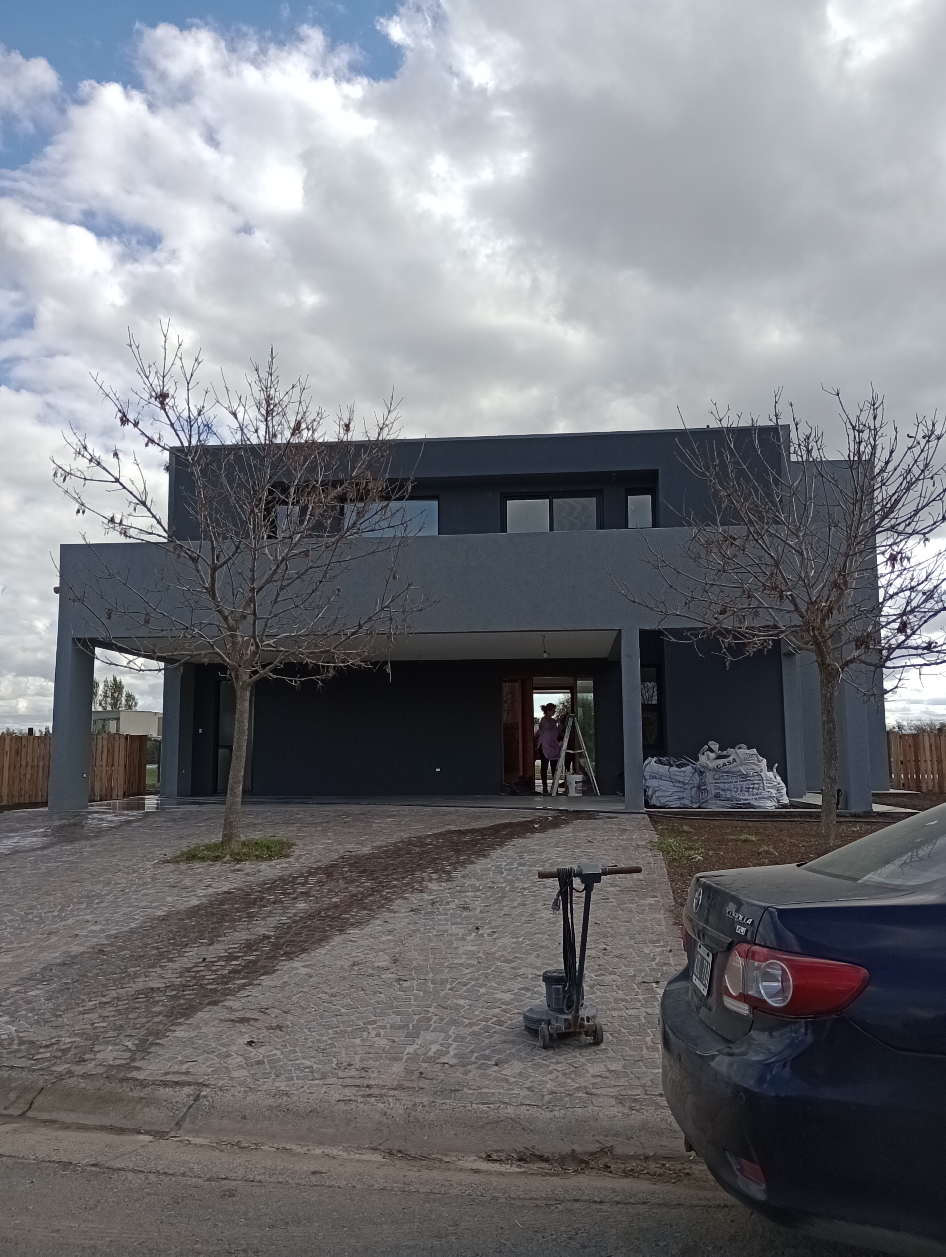 Vivienda moderna de fachada gris en barrio cerrado, GBA